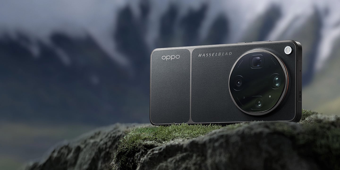 一款深灰色荔枝紋皮革質感的 OPPO 智慧型手機 OPPO Find X9 Ultra ，配有圓形 Hasselblad 鏡頭模組，橫放於苔蘚岩石上，背景為霧氣繚繞的雪山。