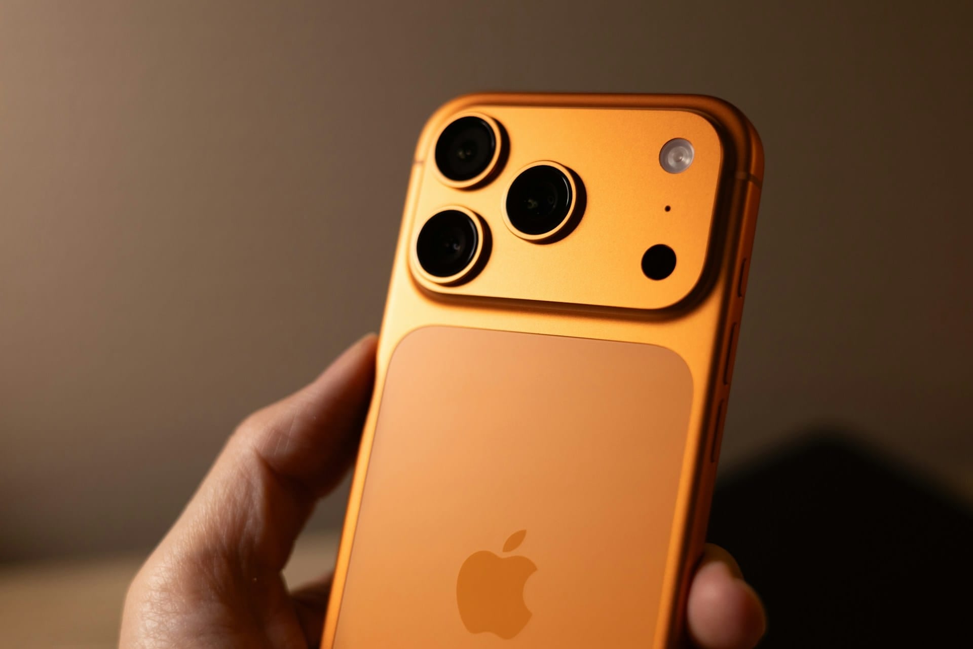 iPhone 17 Pro Max 橘色機身與三鏡頭相機模組特寫,展現 Apple 旗艦手機外觀設計